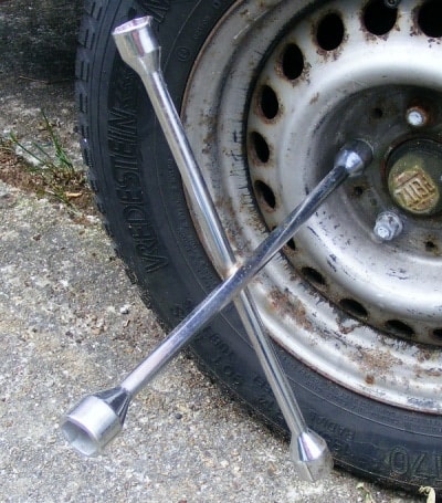 A cross-bar wrench can help tighten the lug nuts